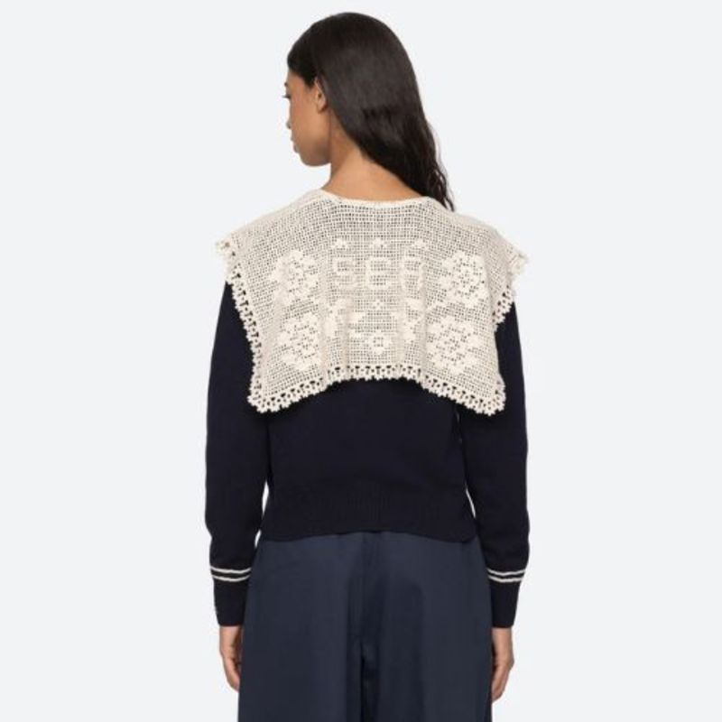 The Marie Cardigan by SEA combines effortless elegance with luxurious comfort. This sophisticated knit features a flattering v-neckline, intricate crochet capelet detail, and an embroidered 'Sea' logo on the cuff. Crafted from premium extra fine merino wool with cotton combo accents, it delivers a soft, breathable wear that moves with you. The relaxed button-front silhouette strikes the perfect balance between polished and comfortable, making it an essential layering piece for any wardrobe. 