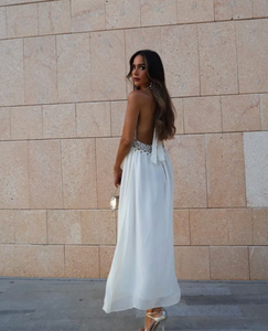 Indulge in the luxurious charm of our Rosalinda Dress. Made with cotton, this bohemian white dress features intricate sequin and pearl detailing. The sleeveless design and high waist create a flattering A-line silhouette, while the open back adds a touch of allure. Elevate your style with this dreamy, ethereal piece.