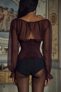 Indulge in luxury with the Chianti Silk-chiffon Blouse. The adjustable neckline and delicate silk ties exude elegance, while the boning and elastic ensure a perfect fit. With smocking and lace-up details at the back, this bustier blouse will elevate any outfit. Available with a side closure for easy wear.