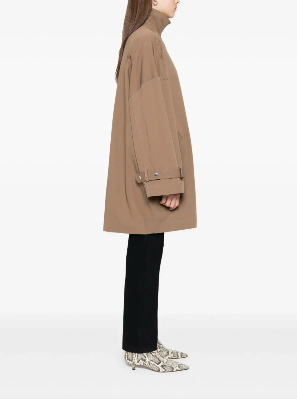 Elevate your everyday style with this hazel brown oversized trench jacket by Toteme — a timeless piece that effortlessly transitions from office to weekend. The classic collar and concealed front zip create a sleek silhouette, while belted cuffs add refined detail and adjustability. Practical side welt pockets keep essentials within reach without disrupting the polished line. Perfect for layering or wearing solo, this relaxed-fit jacket delivers sophisticated versatility that works season after season.