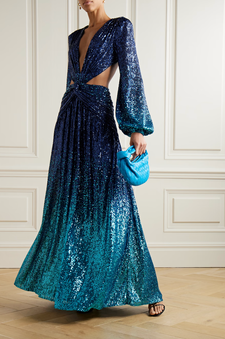 This PatBO gown is the epitome of attention-grabbing eveningwear. Crafted from mesh and adorned with light-reflecting sequins, it features a stunning ombré effect that fades from dark to light blue. The plunging neckline is complemented by dramatic waist cutouts and an open back, adding a touch of sensuality to this stunning piece.