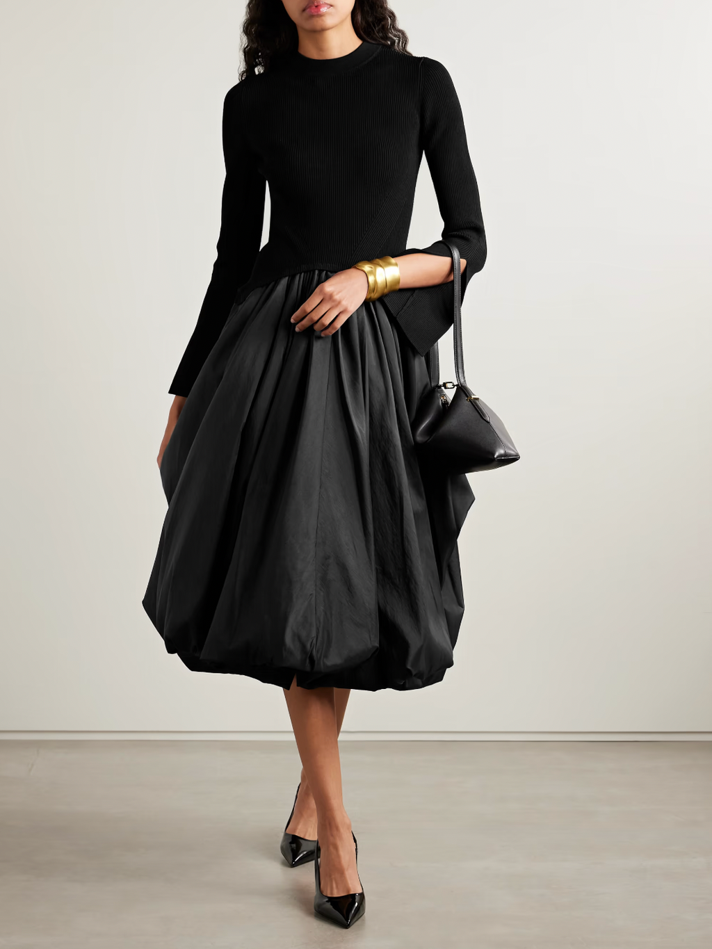 The Kenlie Ribbed-Knit and Taffeta Midi Dress by Simkhai combines a sleek, fitted bodice with a voluminous taffeta skirt that maintains its fullness thanks to soft pleats and a charming bubble hem. This elegant design offers a flattering silhouette that stays graceful whether you’re standing or sitting. Perfect for special occasions, pair it with pumps and understated jewelry to complete a sophisticated and captivating look.