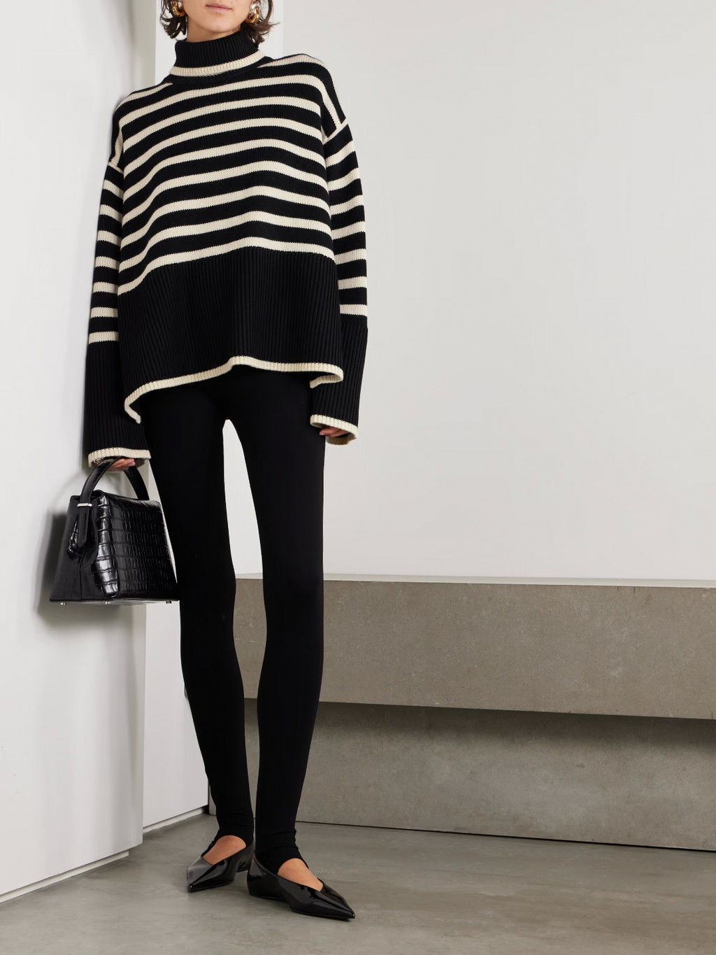 This striped wool-blend turtleneck sweater from TOTEME combines timeless style with cozy comfort. Crafted from a soft blend of wool and organic cotton, it features a relaxed fit and a classic turtleneck, making it perfect for layering. The iconic stripes add a refined touch, while the breathable fabric ensures warmth without bulk. Pair it with tailored pants for an effortlessly polished look that lasts season after season.