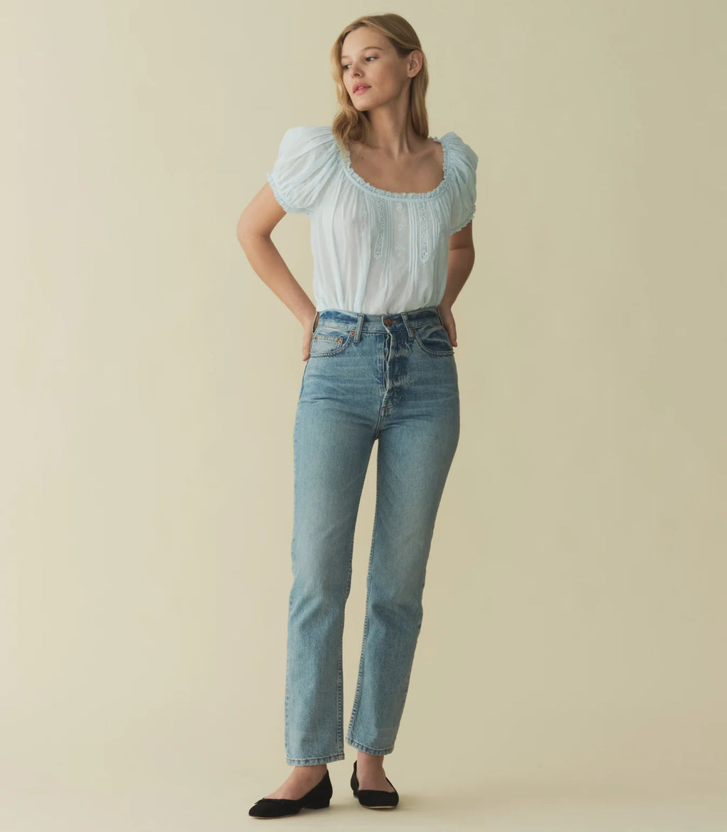 Rendered in 100% organic cotton voile, the Frederica Top features a breezy silhouette, a round neckline, and short puffed sleeves adorned with scalloped lace. Alternating pintuck clusters, lace, and delicate floral embroidery decorate the front. Leave it loose, or tuck it into your favorite pair of high-waisted jeans.