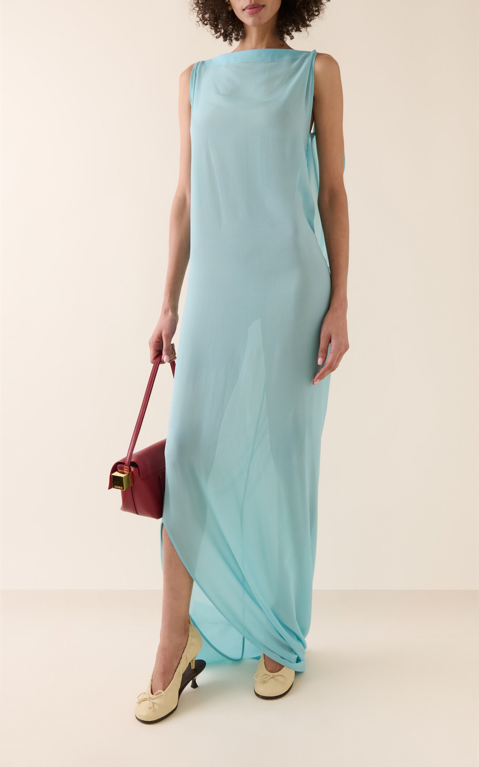 Experience the ethereal elegance of the Ameno dress by Jacquemus, crafted from light-as-air silk chiffon that drapes effortlessly along your back. Its flowing train mirrors the gentle movement of water, creating a captivating silhouette that turns every step into a statement of grace. Elevate your wardrobe with this stunning design that promises both beauty and fluidity.