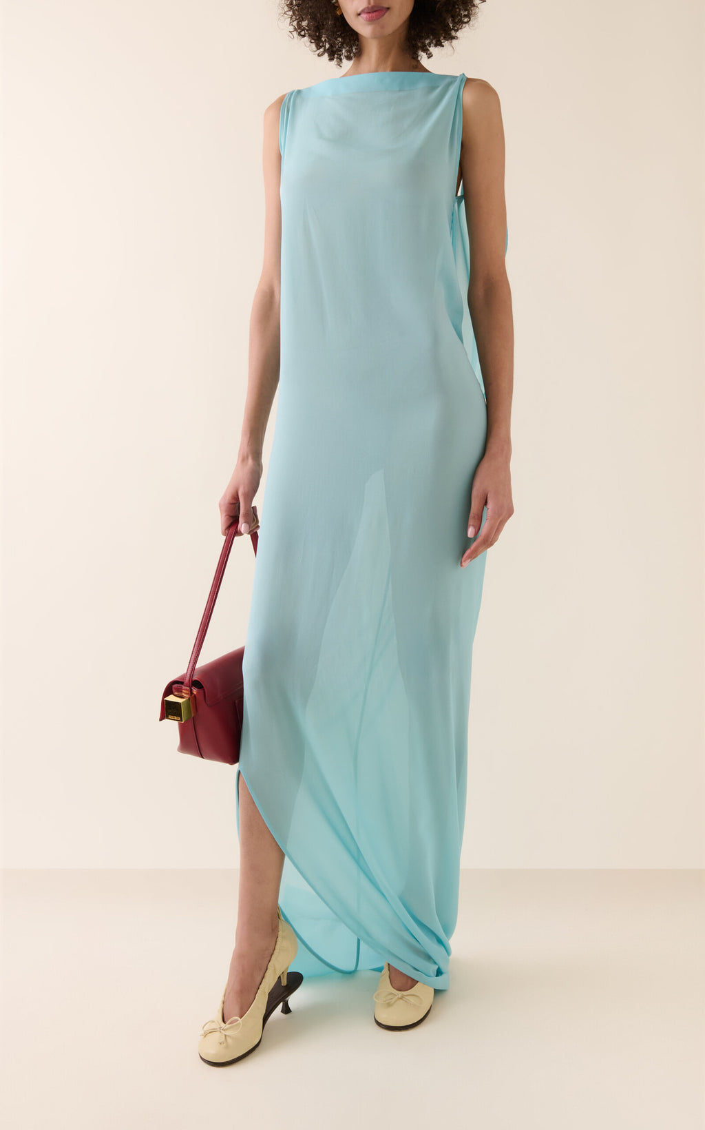 Experience the ethereal elegance of the Ameno dress by Jacquemus, crafted from light-as-air silk chiffon that drapes effortlessly along your back. Its flowing train mirrors the gentle movement of water, creating a captivating silhouette that turns every step into a statement of grace. Elevate your wardrobe with this stunning design that promises both beauty and fluidity.