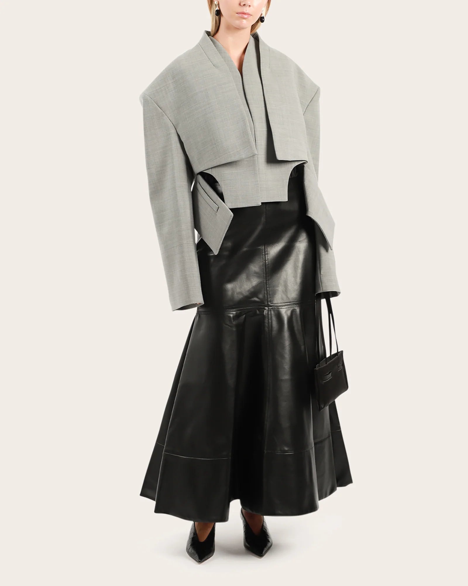 Elevate your wardrobe with this statement cropped jacket by Awake Mode that seamlessly blends bold design with everyday wearability. Featuring dramatic dropped shoulders, voluminous wide sleeves, and an attached insert vest, this piece commands attention while remaining surprisingly versatile. Strategic cutout details at the front create an asymmetrical silhouette that flatters and intrigues, while practical side pockets keep you functional. 