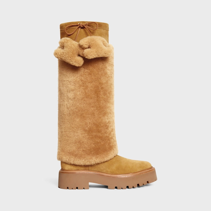 Challenge the norm with the CELINE Suede Calfskin Bulky Highboot. Crafted with luxurious shearling and suede calfskin, this boot is adorned with tassels featuring the iconic TRIOMPHE logo. Embrace your boldness and elevate your style with these high-quality, statement-making boots.