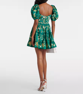 The Manzanilla Mini Dress in Neutral showcases tropical-inspired design through vibrant prints and a breezy, flattering silhouette. Made from 100% cotton poplin, it offers breathability and comfort. Key features include a deep V-neckline with an adjustable drawstring for a customized fit, short puff sleeves that add a touch of elegance, and a tiered A-line skirt that enhances movement and shape. 