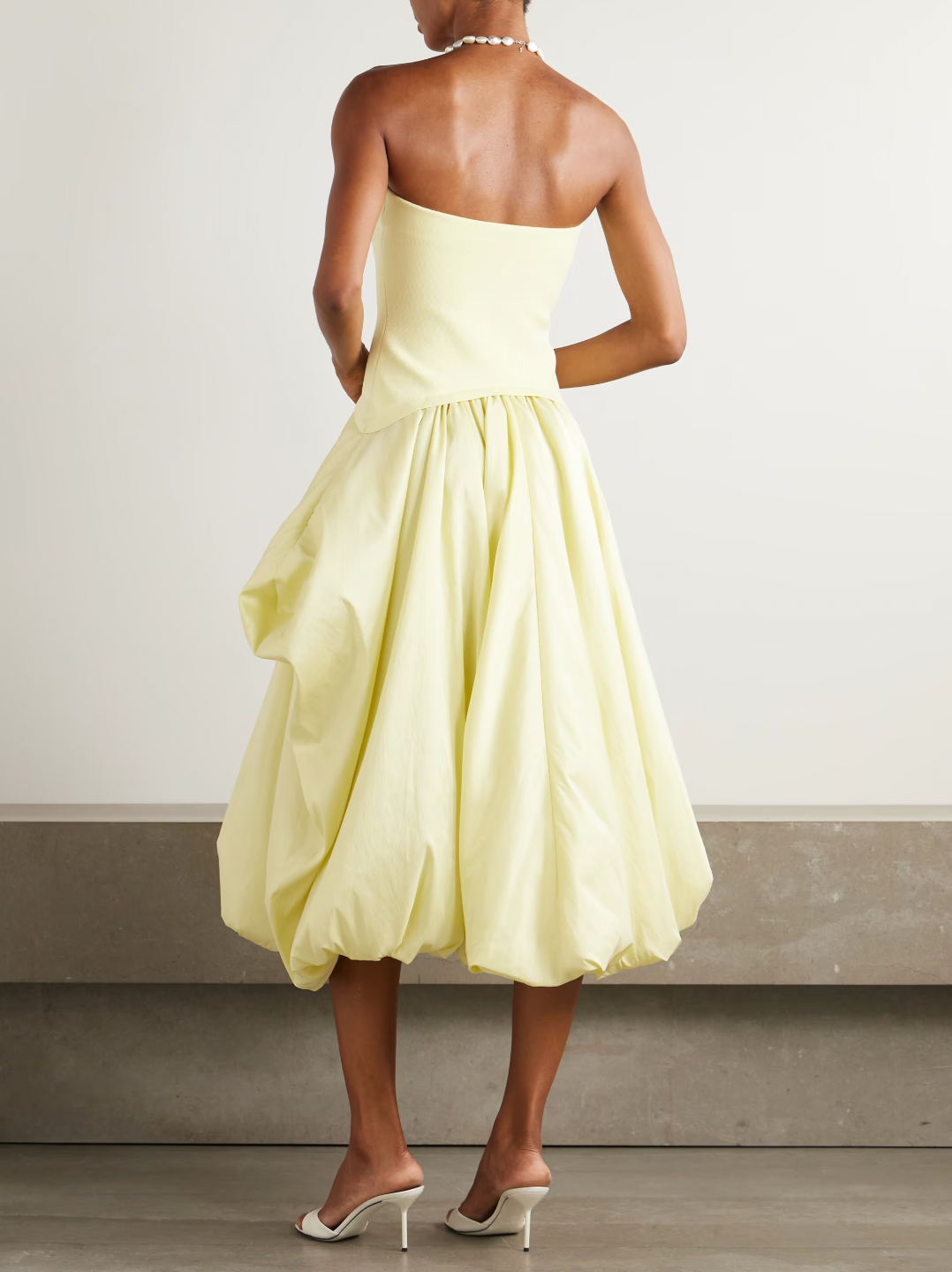 Experience elegance with SIMKHAI’s Izzy Stretch-knit and Gathered Taffeta Midi Dress. Featuring a fitted stretch-knit bodice and a voluminous taffeta skirt in a radiant Sunglow yellow, this strapless design sculpts your silhouette with a gathered waist and an eye-catching asymmetric bubble hem. Perfectly balanced and uniquely stylish, it’s an unforgettable choice for making a bold, sophisticated statement.