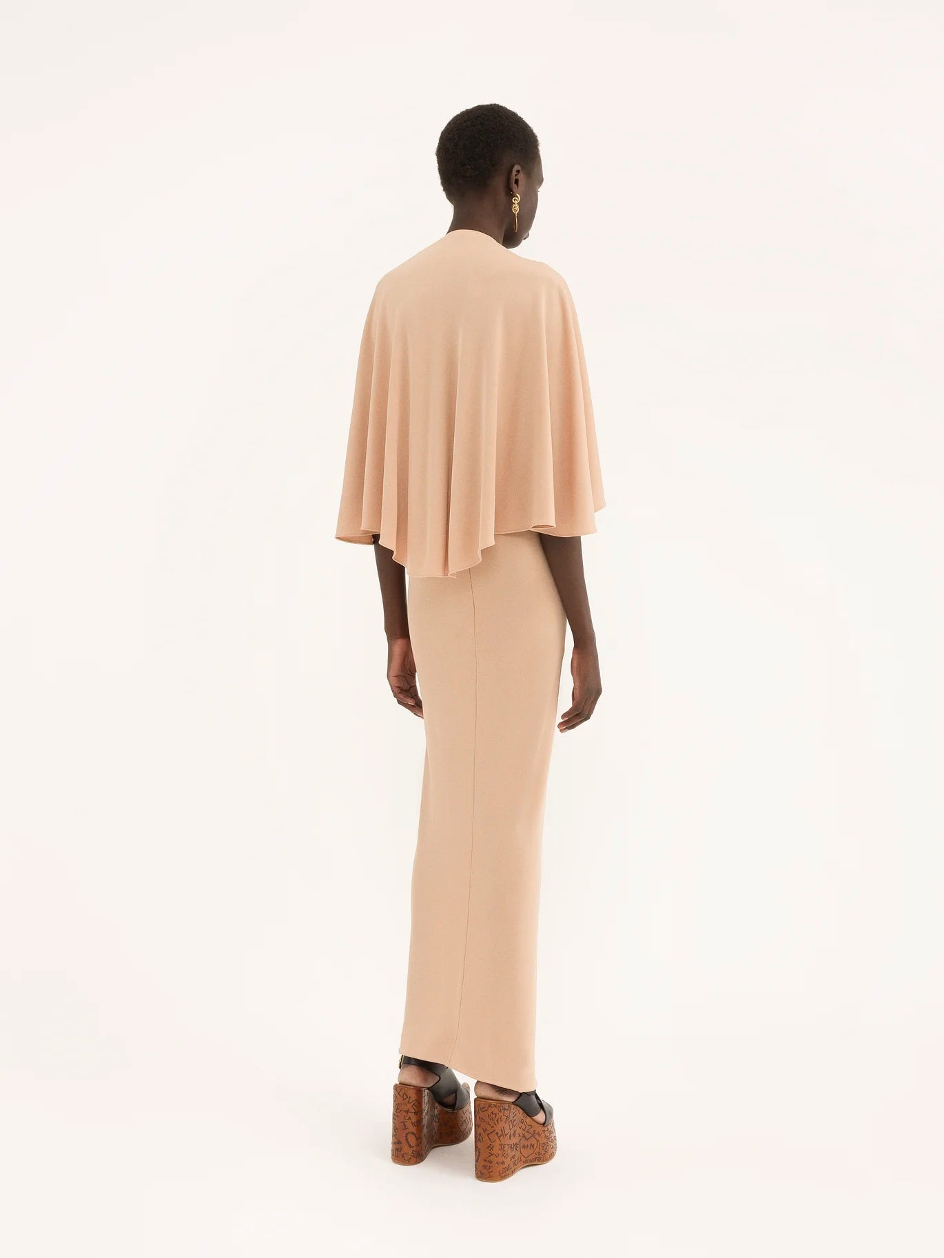 Add an elegant touch to your wardrobe with our Chloe Long Cape Dress. Crafted from luxurious fluid crêpe jersey, this dress exudes sophistication and grace. The flowing cape design adds a touch of drama, making it the perfect statement piece for any special occasion. Elevate your style with this exclusive dress.