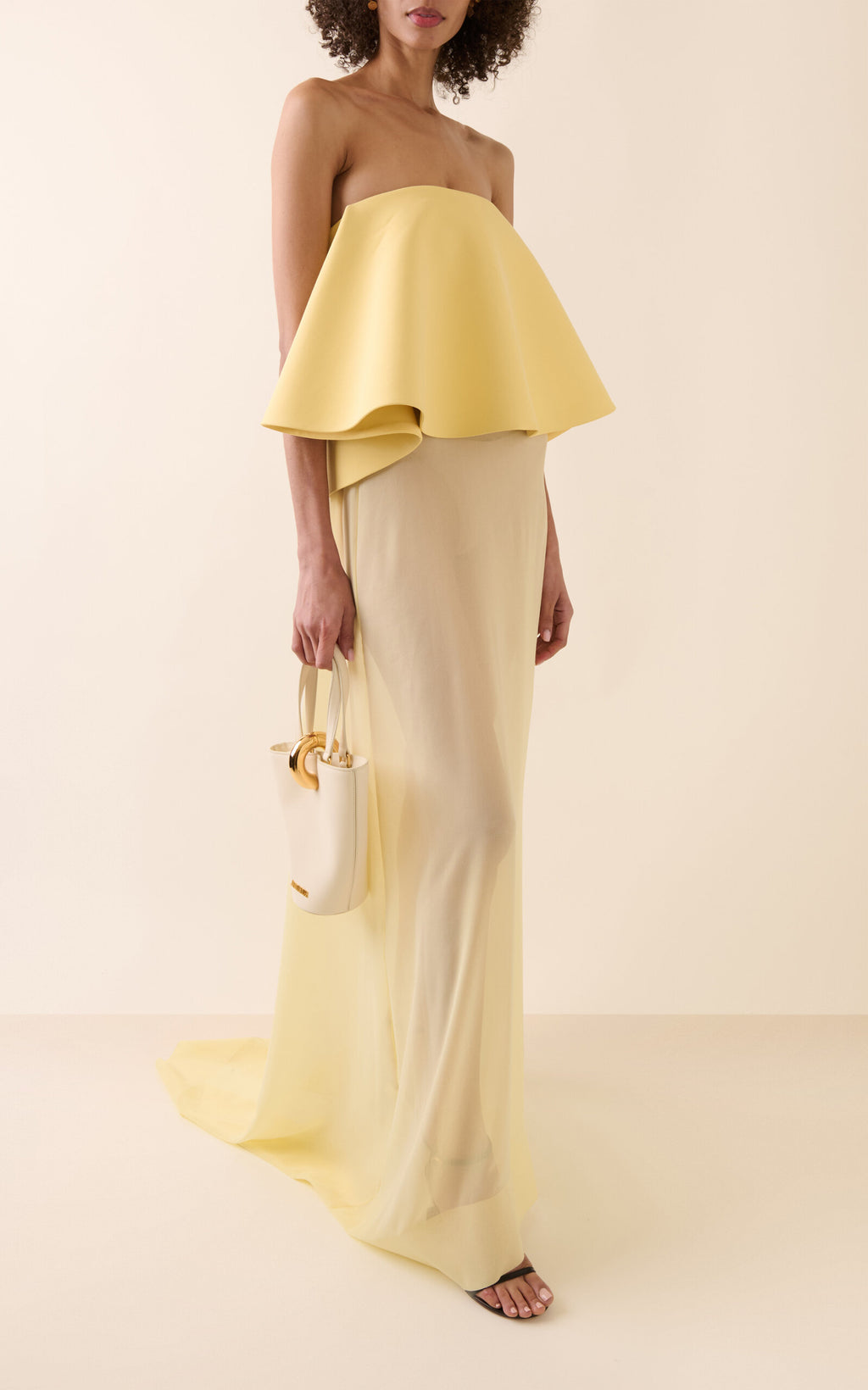 La Robe Vela by Jacquemus combines a structured crepe bodice with a flowing silk chiffon skirt, offering an elegant silhouette that moves with ethereal lightness. Perfect for those who desire sophistication paired with delicate softness, this dress enhances your presence with its refined yet airy design. Experience timeless elegance that effortlessly captures attention.