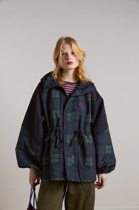 Embrace rainy days with the Liu Coat from Damson Madder, featuring a classic Black Watch tartan design crafted from shower-resistant fabric. Its balloon-style cuffs, adjustable hood, and cinchable waist offer both comfort and a flattering silhouette, while signature 'DM' embroidery adds a touch of distinction. Equipped with practical pockets and thoughtful details, this coat effortlessly combines style and functionality, making it the perfect shield against wet weather.