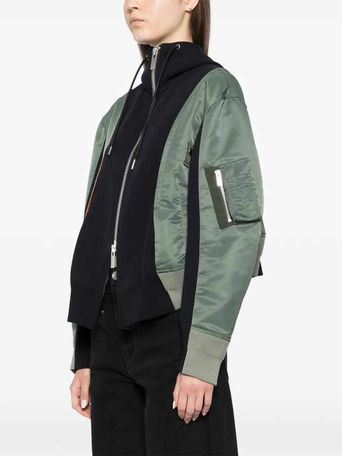 This Panelled Bomber Jacket from Sacai redefines the classic MA-1 with its deconstructed, modern design. Crafted from a cotton-blend shell and complemented by ribbed-knit panels, it offers both comfort and style. Grosgrain trims accentuate the pockets, while a vibrant orange lining adds a bold pop of color when worn unzipped. Ideal for those who want a standout piece that blends edgy fashion with everyday wearability.