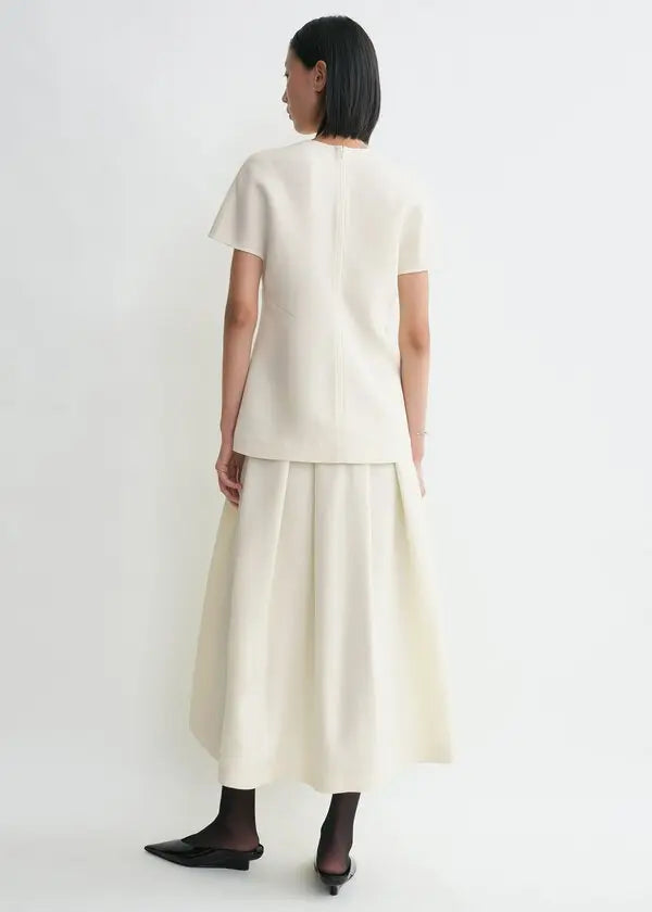 Elevate your wardrobe with this sophisticated TOTEME cap-sleeve top, designed for the modern woman who values refined elegance. The longline silhouette flatters your frame while the distinctive twisted seams add architectural interest to every wear. Crafted from luxurious double-faced cady blended with wool and silk, this piece offers both comfort and durability. The concealed back zipper ensures a seamless, polished look. 