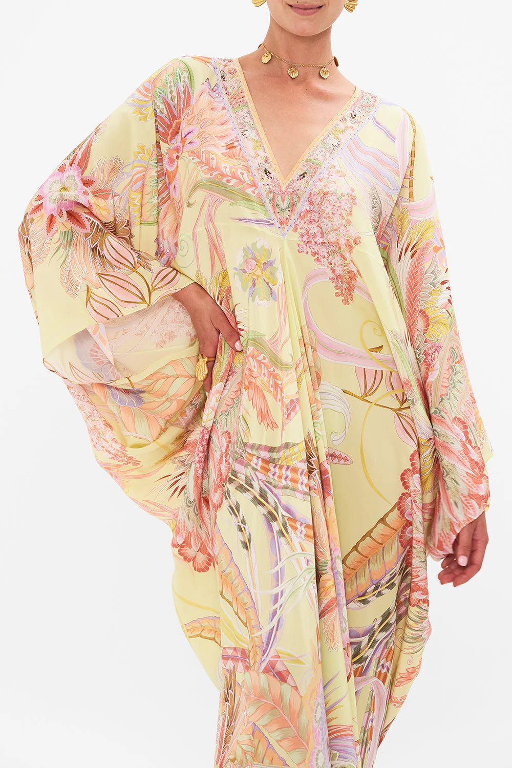 Indulge in the enchanting T Shape Long Kaftan, featuring delicate butterflies and florals on luxuriously floaty silk. The draping design tapers towards the hemline for a elegant silhouette. A deep V neckline with sparkling crystal embellishments adds allure. With a relaxed oversized fit and maxi length, this is a timeless treasure for day or night.