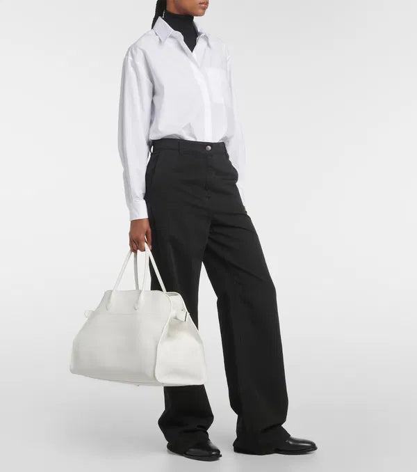 Introducing the Soft Margaux 17 Bag in White by The Row, now in luxurious grained leather. Handcrafted in Italy, this spacious tote is the perfect blend of style and comfort. Twin rolled handles, gusseted sides, and toggle closure make it both functional and fashionable. Upgrade your everyday with this must-have accessory.