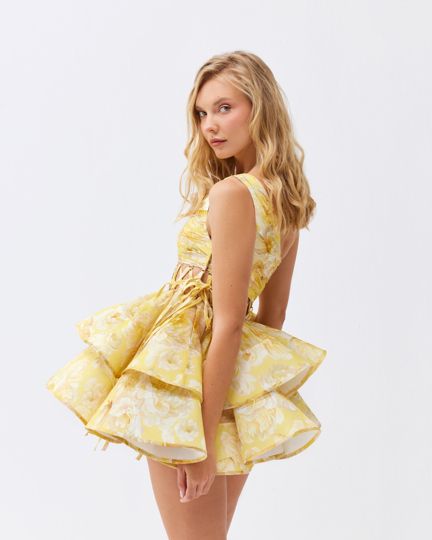 The Iris Mini Dress by YVON combines premium linen silk fabric with a delicate yellow floral print inspired by fairy forest blossoms. Its handcrafted asymmetrical bodice enhances feminine contours with refined subtlety, while the adjustable waist lacing ensures a perfectly sculpted silhouette. This dress expertly merges romantic elements with sophisticated craftsmanship, making it an exceptional choice for those seeking elegance with distinctive style.