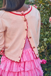 The Renton Pullover is a charming blend of cotton and wool, adorned with a delightful strawberry and cherry motif. Hand-crocheted strawberries add a touch of whimsy. With a shrunken fit and ribbed neckline, cuffs, and border, this sweater is both cozy and stylish. Adorned with strawberry buttons down the back, it's the perfect addition to any wardrobe.