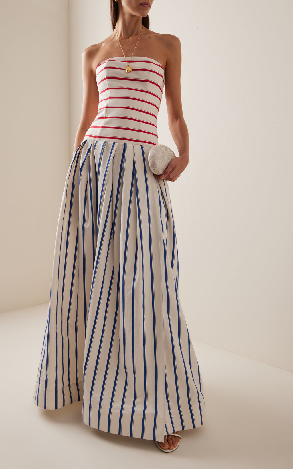 This strapless striped cotton gown by Rosie Assoulin features a sophisticated drop-waist silhouette that flatters the figure while offering comfort. Crafted from breathable cotton, its clean lines and bold stripes create a modern yet timeless look, ideal for elegant occasions where effortless style is paramount.