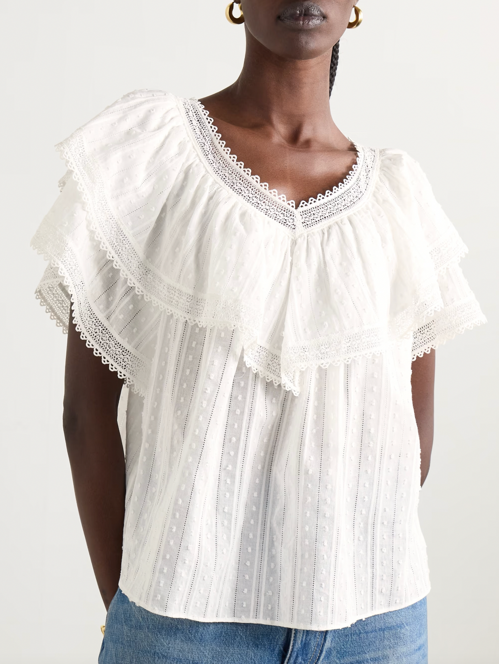 The Cosenza blouse from DÔEN features a delicate fluttery ruffled panel that elegantly highlights the V-neckline and shoulders. Crafted from lightweight fil coupé cotton-voile and accented with airy crochet trims, it offers both comfort and charm. Perfectly versatile, this blouse pairs effortlessly with jeans or flowy skirts, making it a stylish choice for any occasion.