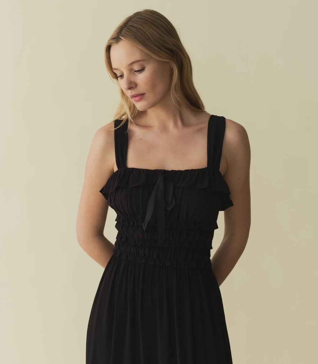 The Carolynn Dress—in a lightweight blend of rayon and viscose—features a square neckline, a gathered bust, and a fitted bodice framed with petite ruffles. Elastic lends give to the bust and waist, giving way to a swingy, ankle-length skirt.