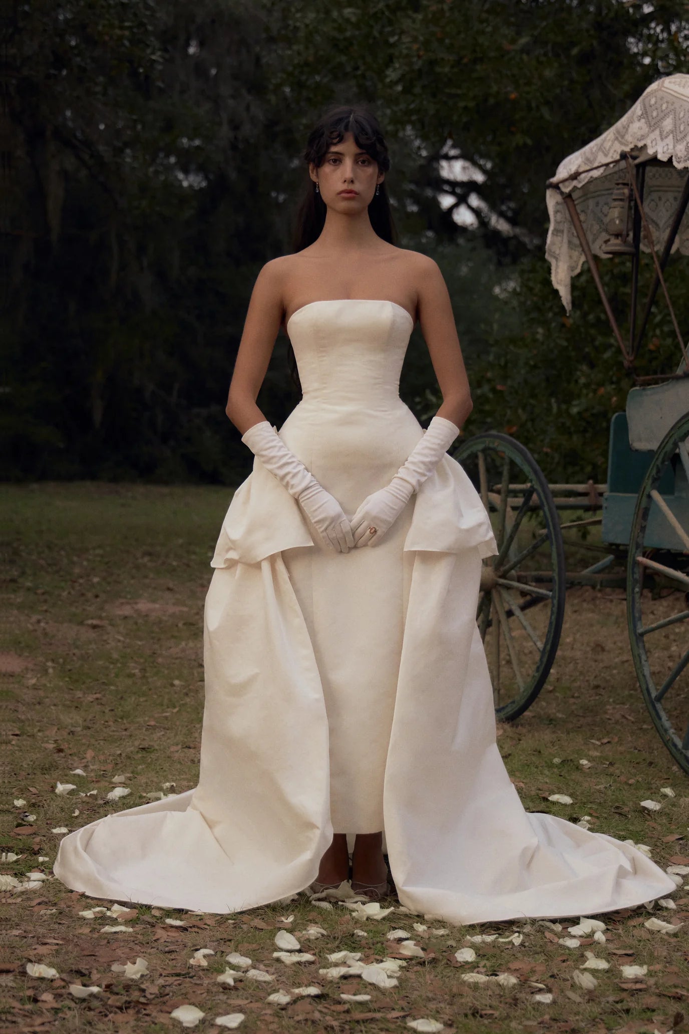 Elevate your style with our Funny Face Gown in Ivory. This strapless column gown features side bustles and a back peplum, enhanced by a built-in corset and hip padding. The fully functional buttons and invisible zipper add effortless elegance. Stand out in this unique and flattering design!