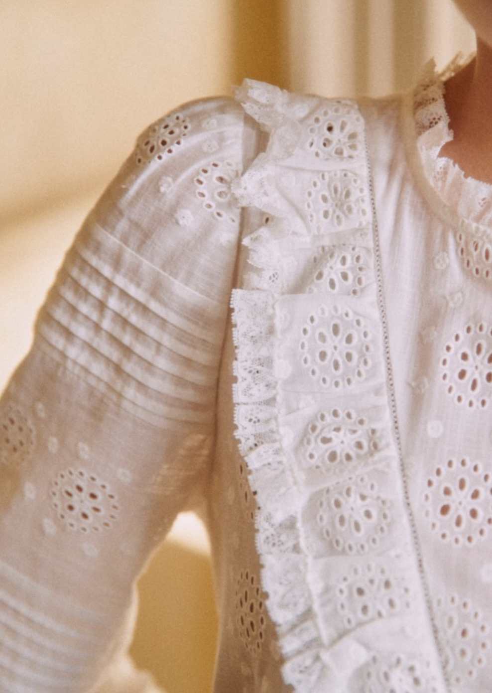 Elevate your wardrobe with the Nele Blouse. Showcasing intricate embroidered detailing and 3/4 length sleeves, this blouse exudes effortless elegance. The high ruffled collar, front ruffles, and pleat details add a touch of sophistication. Finished with delicate mother of pearl buttons, this blouse is the epitome of luxury fashion.