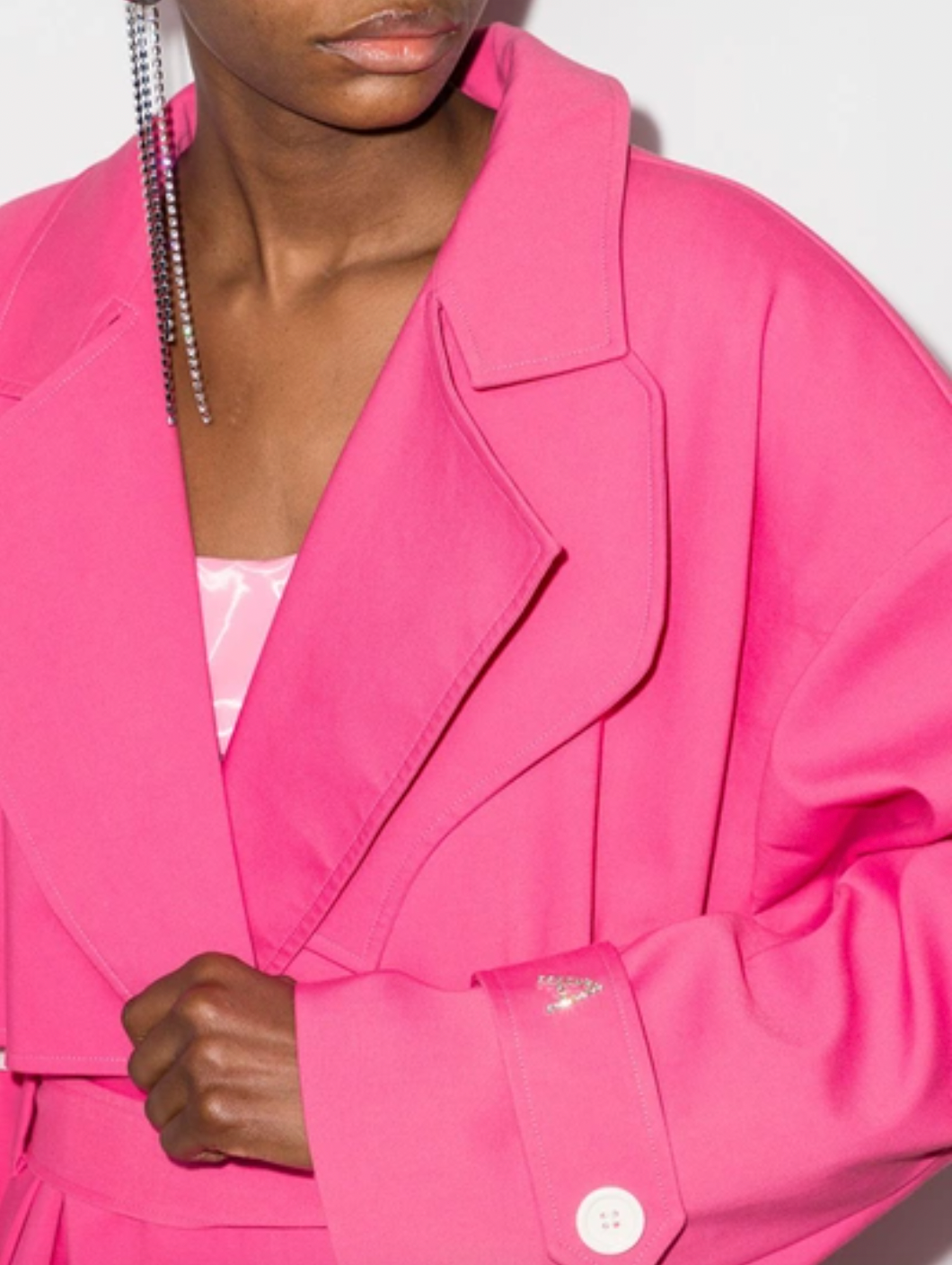 This pink ANOUKI oversized belted trench coat is designed with a wrap silhouette. Boasting a sparkling A logo to the buttoned cuff tab, it features large notched lapels, dropped shoulders, long sleeves, a back storm flap and centre vent, slip side pockets, belt loops and a self-fabric tie belt. Project Runway taught us how to 'make it work,' now flaunt what ANOUKI made you and say Auf Wiedersehen to the other coat-estants.