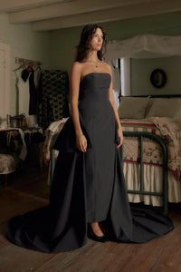 Be the life of the party in our Funny Face Gown Noir. Strapless column gown accentuates curves with built-in corset and hip padding. Side bustles and back peplum add playful flair. Functional buttons and invisible zipper down center back. Be the talk of the town in this daring and stylish gown!