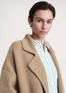 Introducing the Totême Rib Knit Coat, a luxurious and elegant addition to any wardrobe. Keep warm in style with this sophisticated tan coat, boasting a rib knit design for added texture. Elevate your look and feel exclusive in this timeless piece.