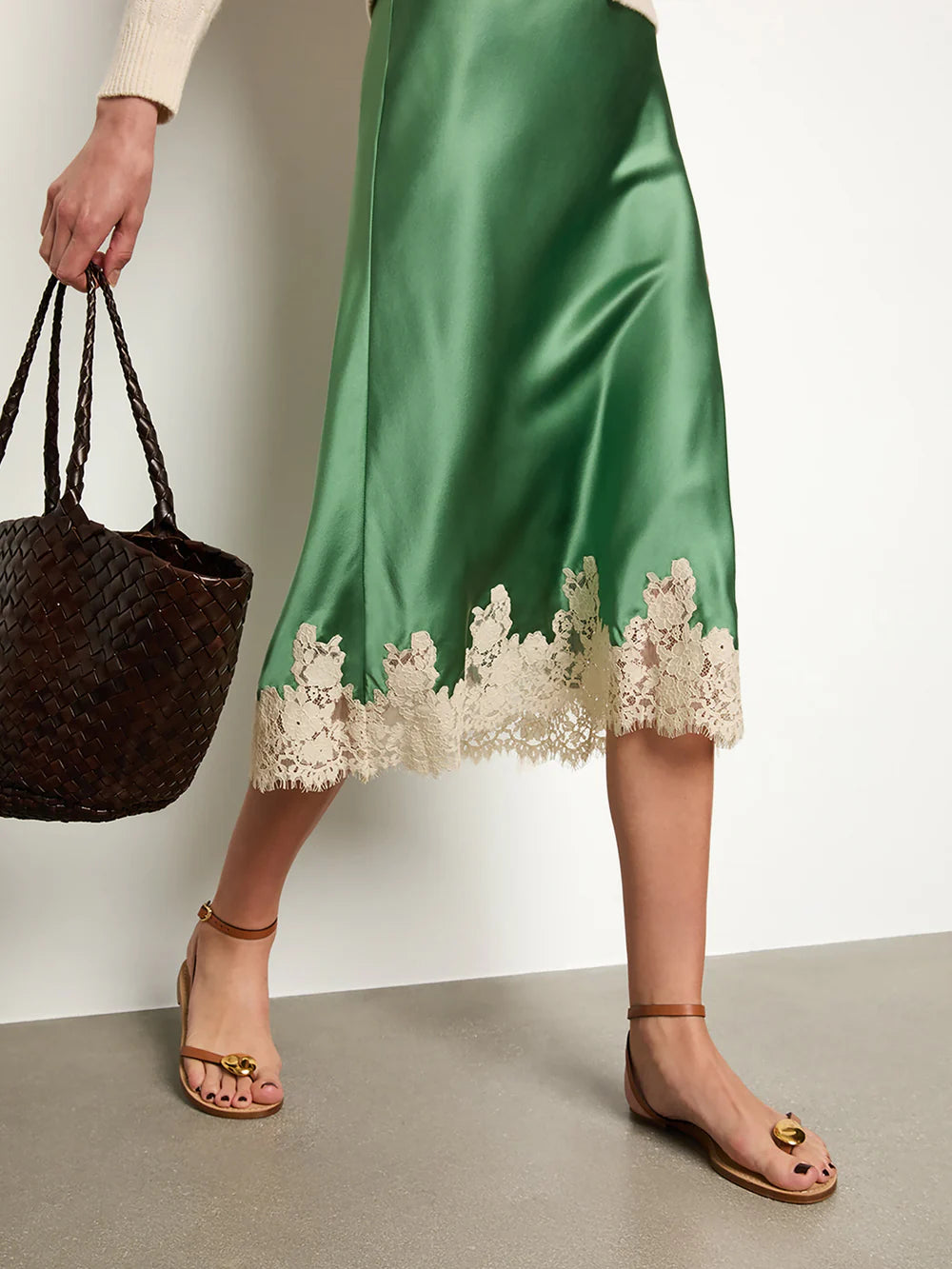 The Elowena Skirt features a scallop-edged elastic waistband for effortless slip-on wear. Crafted from buttery silk and cut on the bias, it drapes fluidly for a graceful silhouette. Its delicate ivory floral-lace hem adds a refined, feminine touch, making this skirt both elegant and comfortable for versatile styling.