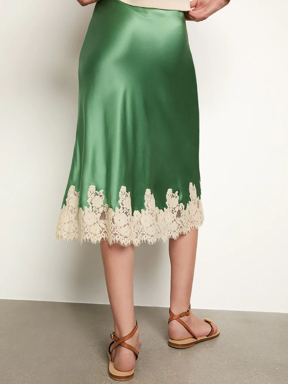 The Elowena Skirt features a scallop-edged elastic waistband for effortless slip-on wear. Crafted from buttery silk and cut on the bias, it drapes fluidly for a graceful silhouette. Its delicate ivory floral-lace hem adds a refined, feminine touch, making this skirt both elegant and comfortable for versatile styling.