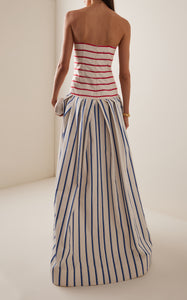 This strapless striped cotton gown by Rosie Assoulin features a sophisticated drop-waist silhouette that flatters the figure while offering comfort. Crafted from breathable cotton, its clean lines and bold stripes create a modern yet timeless look, ideal for elegant occasions where effortless style is paramount.