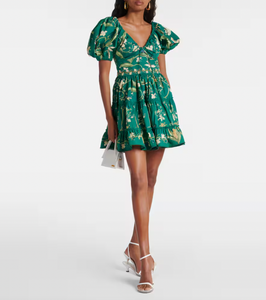 The Manzanilla Mini Dress in Neutral showcases tropical-inspired design through vibrant prints and a breezy, flattering silhouette. Made from 100% cotton poplin, it offers breathability and comfort. Key features include a deep V-neckline with an adjustable drawstring for a customized fit, short puff sleeves that add a touch of elegance, and a tiered A-line skirt that enhances movement and shape. 