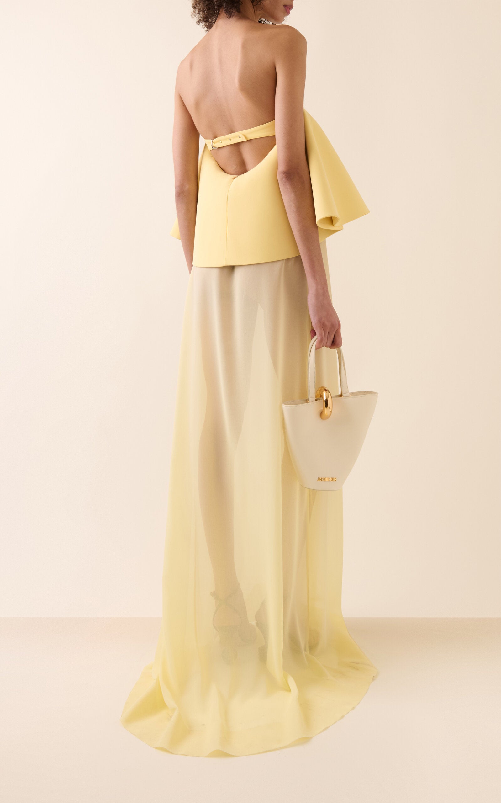 La Robe Vela by Jacquemus combines a structured crepe bodice with a flowing silk chiffon skirt, offering an elegant silhouette that moves with ethereal lightness. Perfect for those who desire sophistication paired with delicate softness, this dress enhances your presence with its refined yet airy design. Experience timeless elegance that effortlessly captures attention.