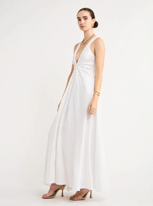 Adorn yourself with the elegance of the Sabrina Linen Maxi Dress in White. Crafted from Flax Linen fabrication for a relaxed easy fit, this maxi dress features a plunging neckline, a gathered twist front feature, functional linen-covered buttons, and a V-line open back with spaghetti tie fastening. With a graceful full skirt, this dress will be your go-to choice for summer getaways, birthday celebrations and refined holiday dressing.