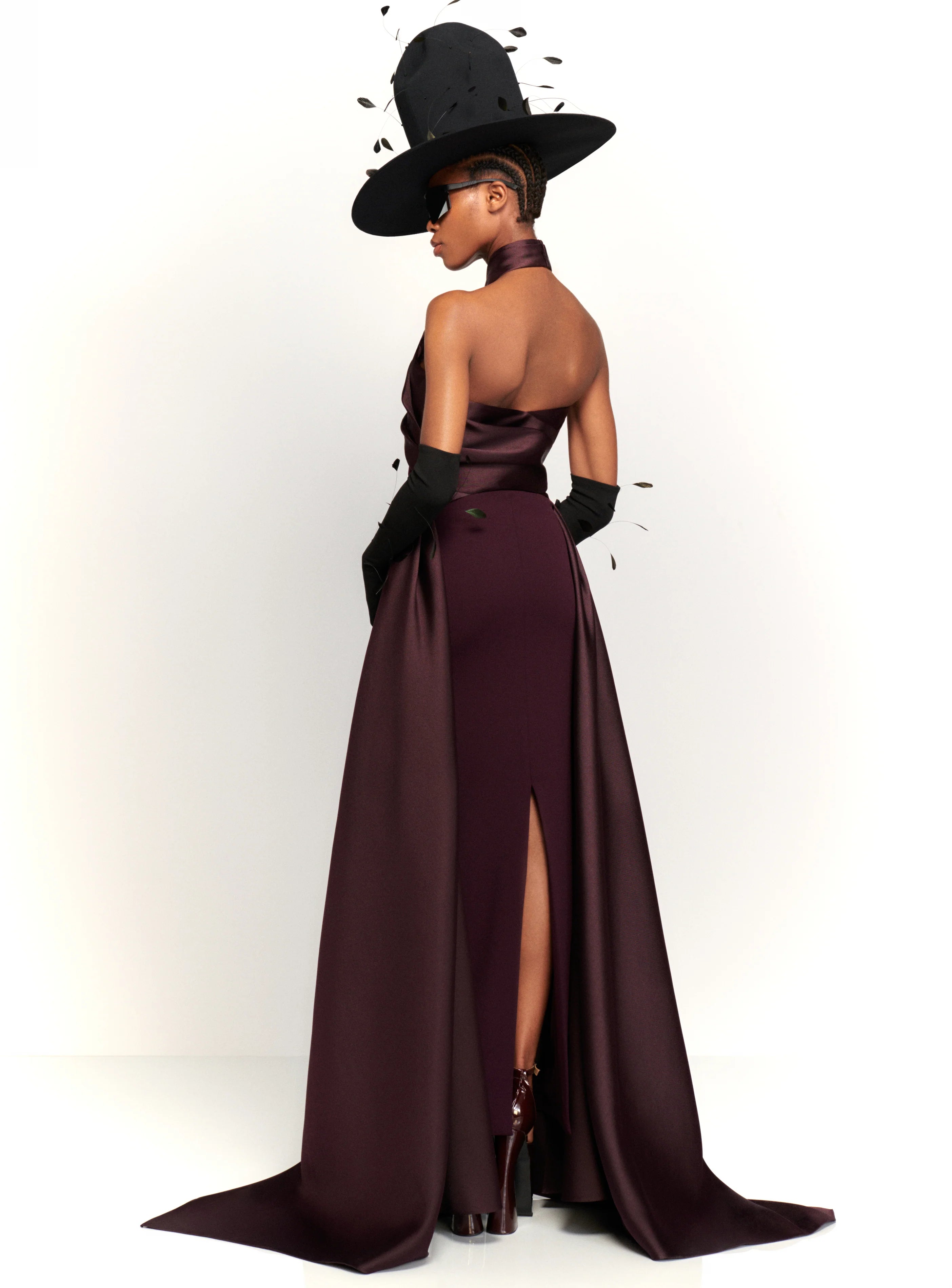 Experience red carpet glamour and drama with the Solace London Rumi Maxi Dress in Plum. This stunning gown is designed to turn heads, with its body-sculpting stretch-crepe fabric and voluminous floor-length hem. The satin-faille wrap detail at the neck and waist adds an extra touch of luxury to this show-stopping dress.