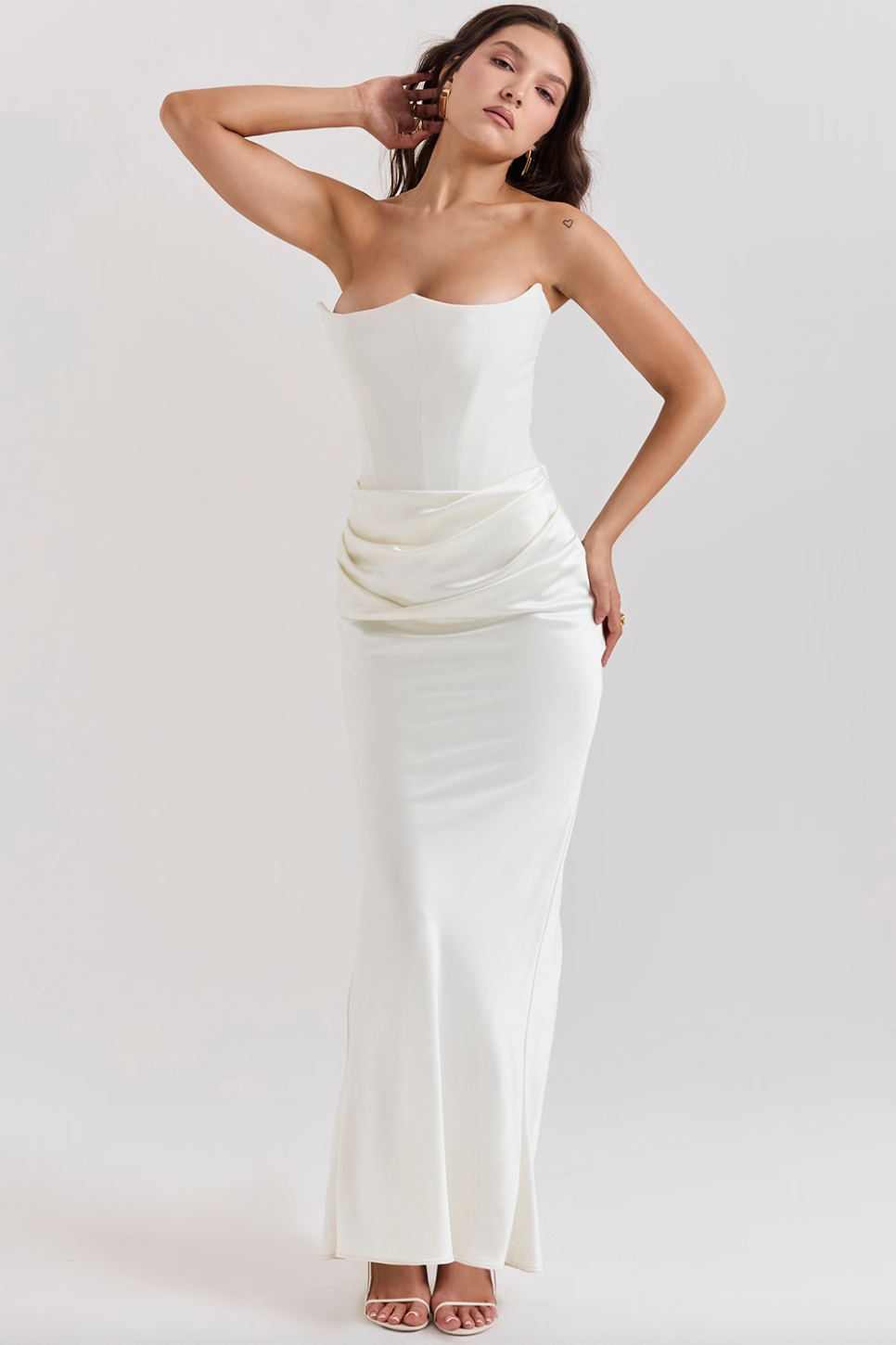 Indulge in luxury with the Ivory Strapless Corset Dress. Perfect for any high-octane occasion, this dress is crafted from stretch crepe and ultra luxe satin. The strapless neckline and boned bodice cinch the waist, while the beautifully draped skirt creates a striking silhouette. Make a statement with its flattering dress.