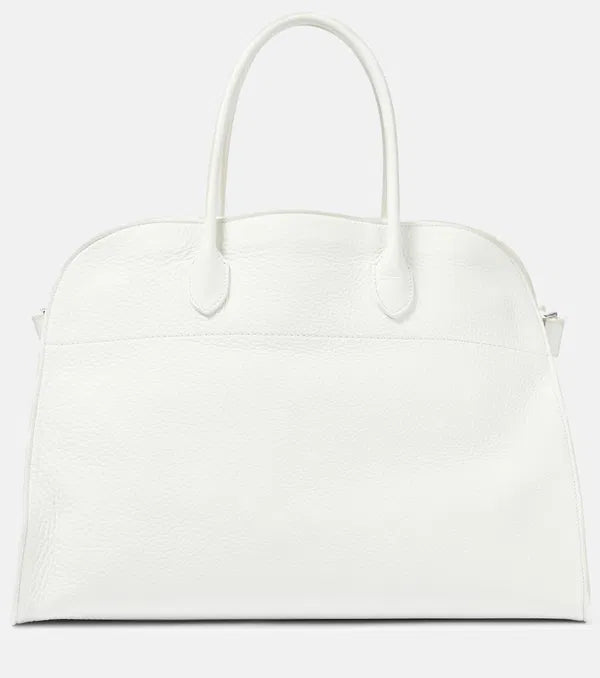 Introducing the Soft Margaux 17 Bag in White by The Row, now in luxurious grained leather. Handcrafted in Italy, this spacious tote is the perfect blend of style and comfort. Twin rolled handles, gusseted sides, and toggle closure make it both functional and fashionable. Upgrade your everyday with this must-have accessory.