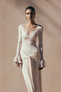 The Electra Maxi Dress combines elegant lace and a flattering fitted silhouette to create a captivating look. Its deep V lace neckline and delicate cut-outs add a touch of allure, while the cascading front-side tie drape enhances graceful movement. Flared layered sleeves bring a vintage charm, and the partial lining ensures comfort without compromising style. Perfect for making a memorable impression at any evening event, this dress shapes a sophisticated and sultry statement.