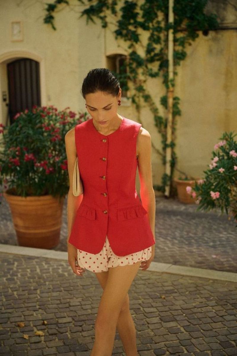 The Matilda Gilet, crafted from 100% linen in a striking red, combines elegance with versatility. Its jewel neckline and flared peplum hem create a refined silhouette, while the adjustable gold buckle at the back allows precise waist customization. Functional welt pockets feature delicate ruffle flaps that can be displayed for added style or concealed for a clean finish. Fully lined with a curved hemline and centre back split, this gilet offers both comfort and tailored sophistication for a polished look.