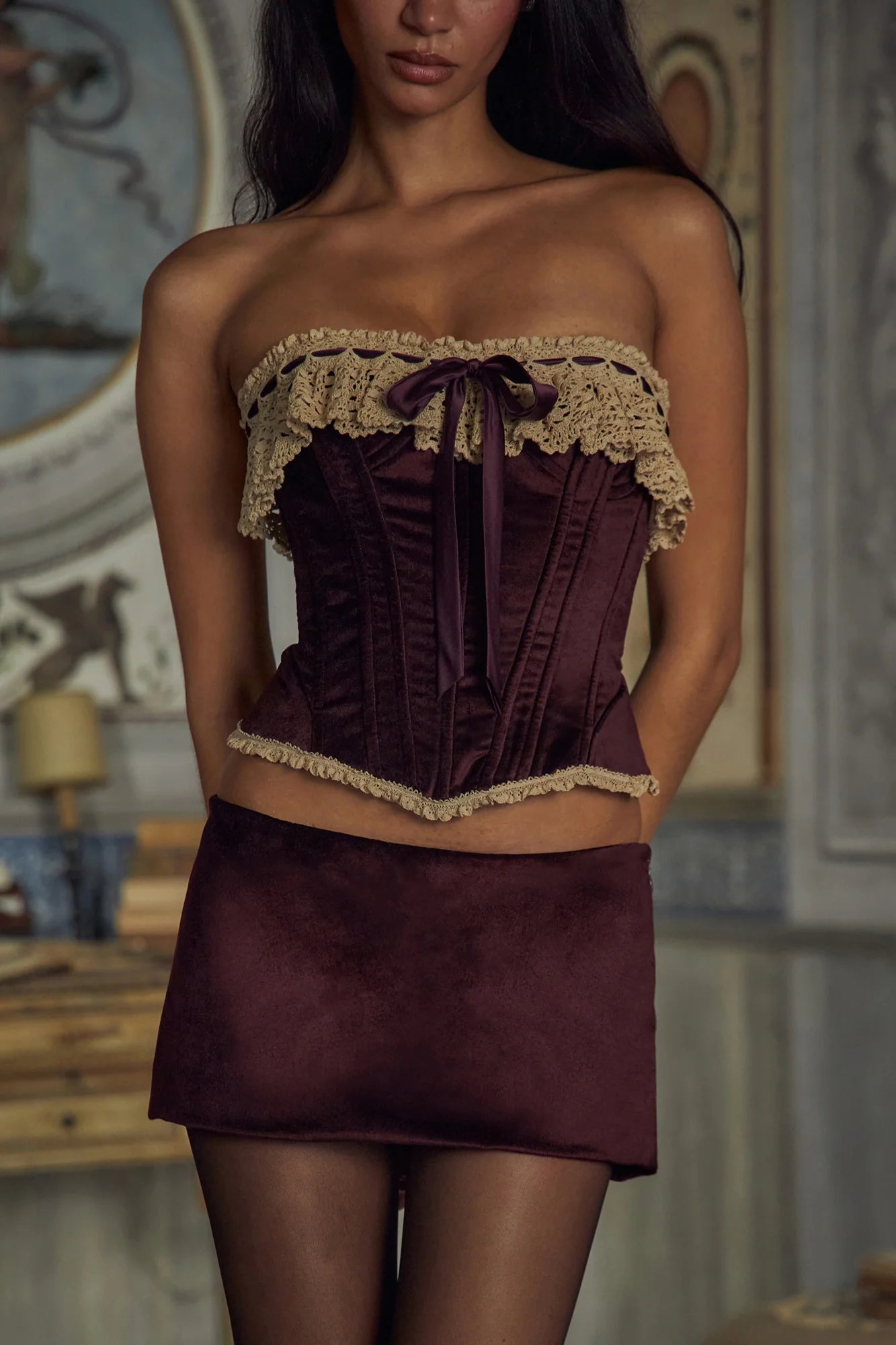 Indulge in opulence with the Victorian Velvet Set. The velvet corset boasts a delicate lace trim and secure silicone gripper while the functional silk ties and bow add a touch of femininity. Boning throughout the bodice accentuates your figure. The matching mini skirt features hidden shorts and an invisible zipper for a seamless silhouette.