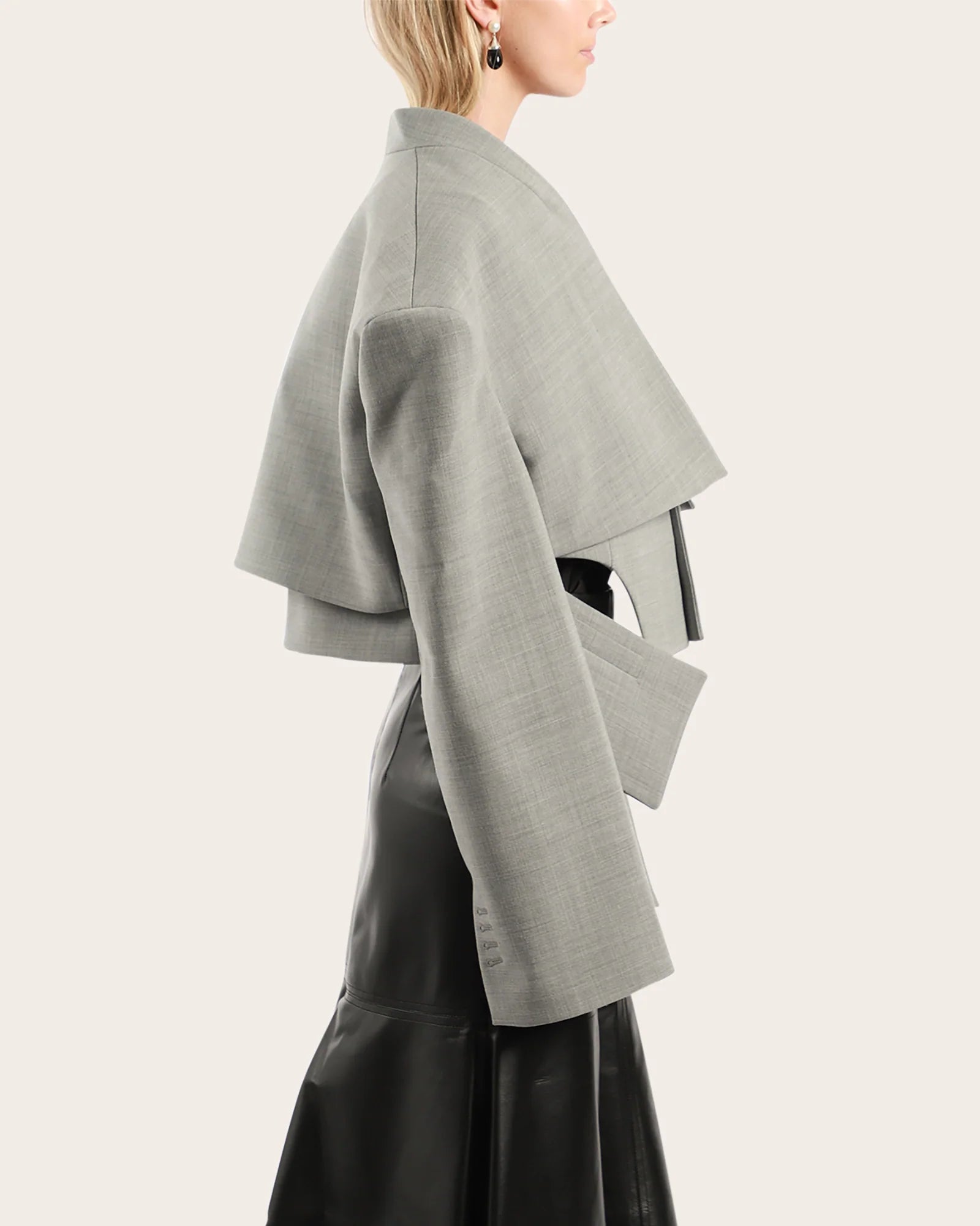 Elevate your wardrobe with this statement cropped jacket by Awake Mode that seamlessly blends bold design with everyday wearability. Featuring dramatic dropped shoulders, voluminous wide sleeves, and an attached insert vest, this piece commands attention while remaining surprisingly versatile. Strategic cutout details at the front create an asymmetrical silhouette that flatters and intrigues, while practical side pockets keep you functional. 