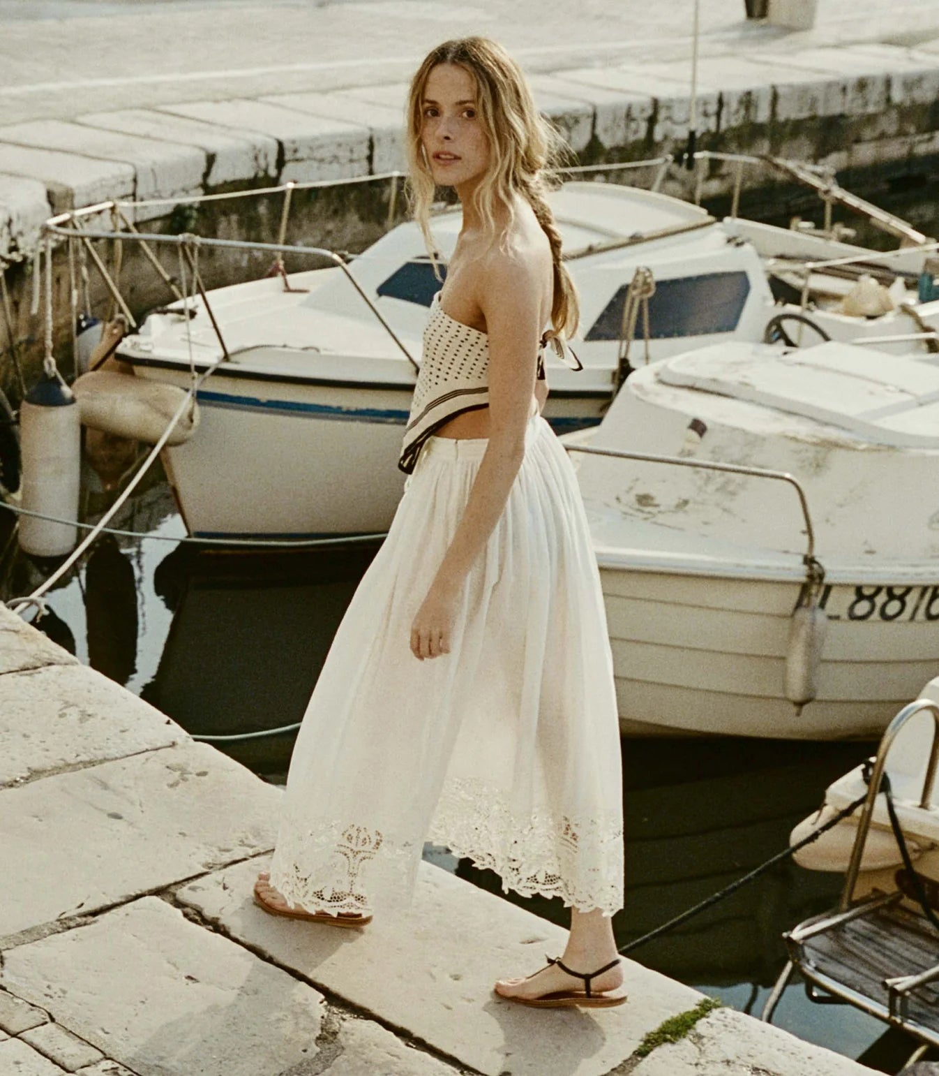 In crisp organic cotton poplin, the antique-inspired DÔEN Heirloom Gloriane Skirt features a high waist with a fixed tie and a full, A-line silhouette. Floral embroidery with hand-done cutwork adorns the hem, which falls to just above the ankle, while an invisible zipper and hook-and-eye closure fastens at the side.