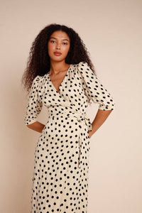 Introducing the Robe Caitlin - a stylish and versatile addition to your wardrobe. This knee-length jacquard dress features a wrap design, puffed sleeves, button accents, a waist-cinching belt, and back gathers for a flattering fit. Elevate any outfit with its playful polka dot pattern.