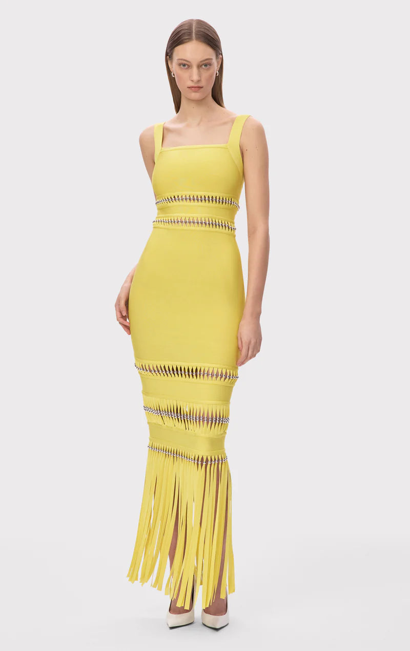 The Ines Gown by Herve Leger is a masterpiece of contemporary sophistication. Its body-contouring midi silhouette flatters every curve, while the striking square neckline commands attention. Hand-placed silver beads catch the light beautifully, creating an enchanting shimmer that draws the eye. Strategic cutouts offer tasteful glimpses of skin, adding an element of allure without compromising elegance. 