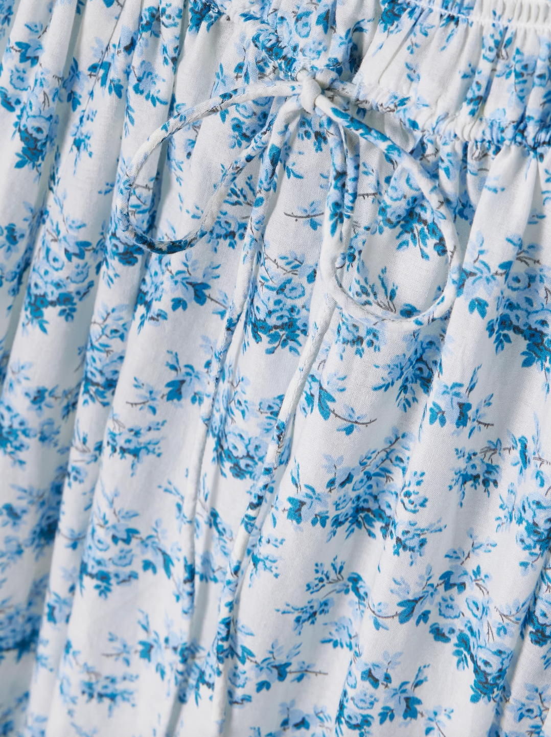 Experience effortless romance with the Ashlynn midi dress by DÔEN. Crafted from breathable organic cotton-voile, its all-over floral print captures a timeless, delicate charm. The shirred bodice offers a comfortable fit, while adjustable ties at the neckline and waist allow you to tailor the silhouette to your liking. Perfect for warm days and graceful evenings, this dress brings Southern Californian ease to your wardrobe with eco-friendly elegance.