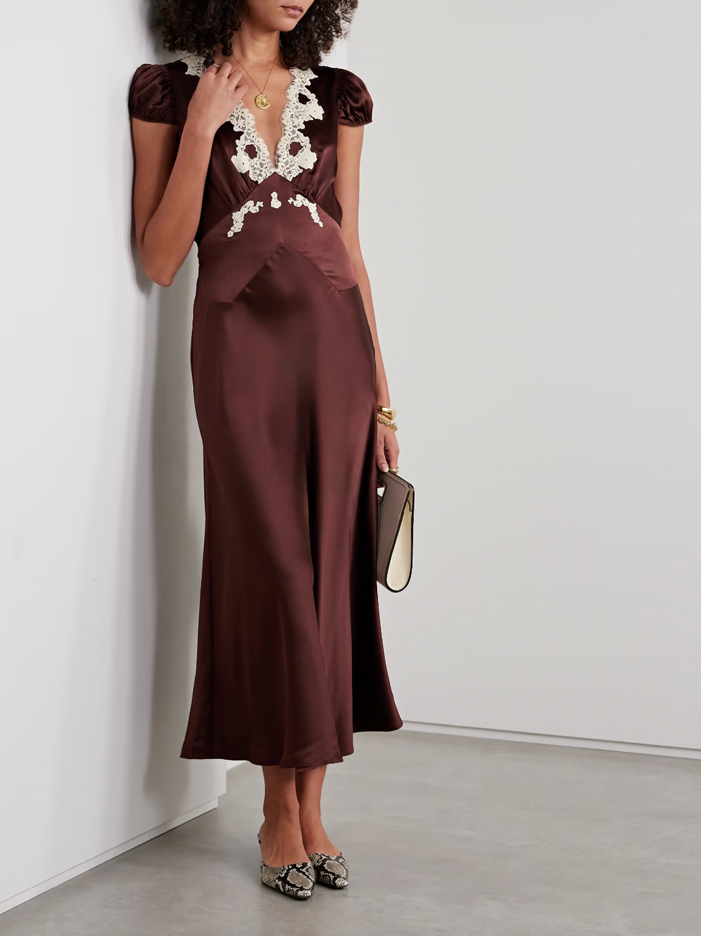 The Silk Lace-Trim Coraline Midi Dress channels the refined elegance of the 1930s with expertly crafted details. Made from lush silk satin, it gracefully drapes the body, enhanced by whimsical gathered cap sleeves. The plunging V-neckline highlights delicate embroidered scallop lace, while the fitted bodice transitions into a flattering bias-cut midi skirt. Adjustable back ties offer a personalized fit, and a subtle embroidered “D” on the bust adds a distinctive signature touch. This dress is a sophisticate