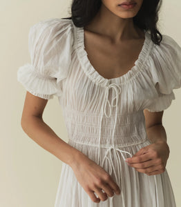 In a soft, lightweight blend of organic cotton and viscose, our beloved Ischia Dress—a Favorite Character that first made its debut in Spring 2021—features double-puffed sleeves and a scoop neckline adorned with petite ruffles and a functional center tie. A smocked bodice with an adjustable waist tie gives way to an ankle-grazing A-line skirt.